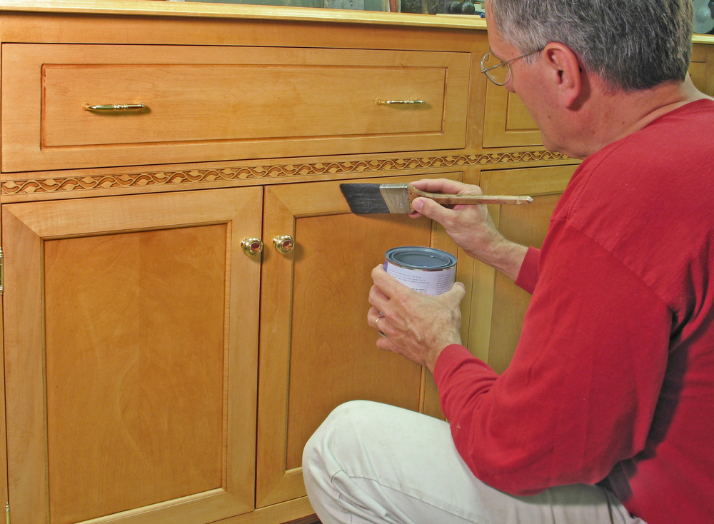 a man is painting kitchen cabinets without sanding