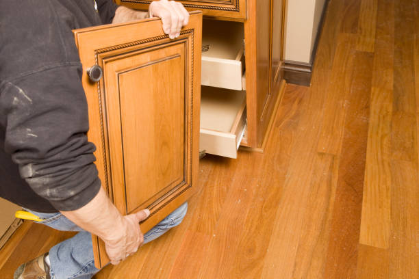 a man removing the cabinet door