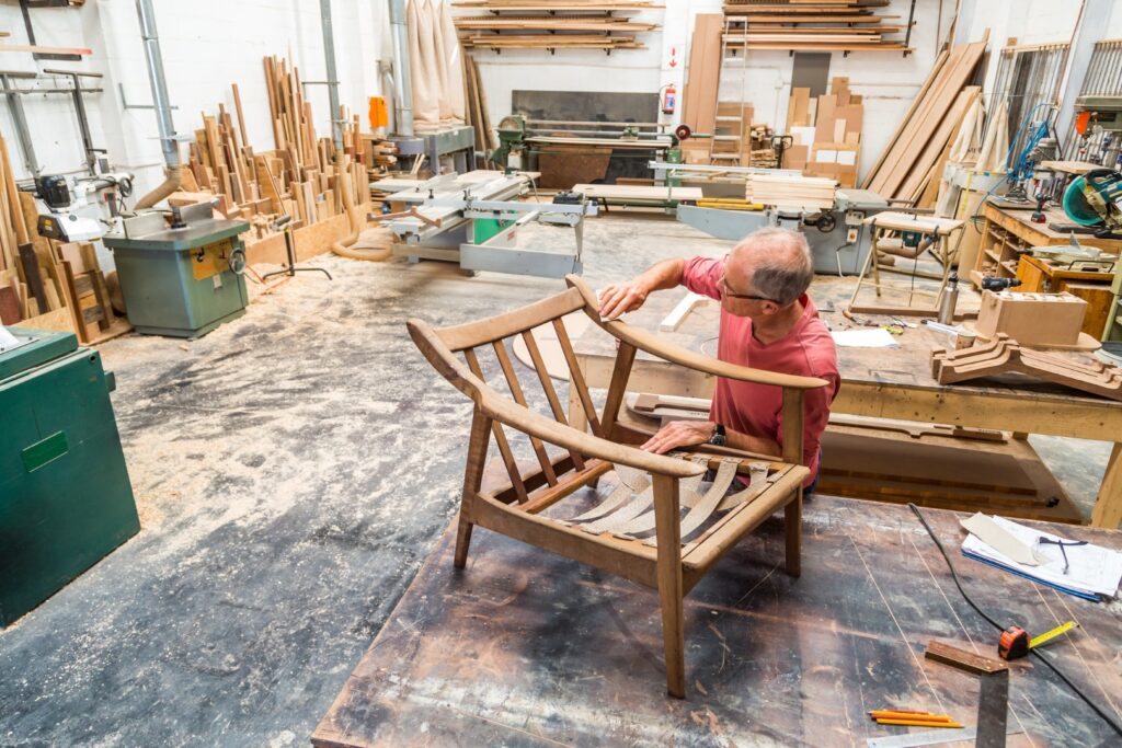 A man is Preparing Sofa in a room where furniture is cluttered