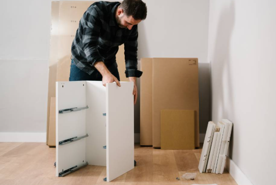 a man is dis assembling furniture